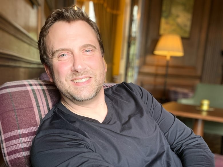 Martin Andresen sitting in a chair with a plaid pattern.