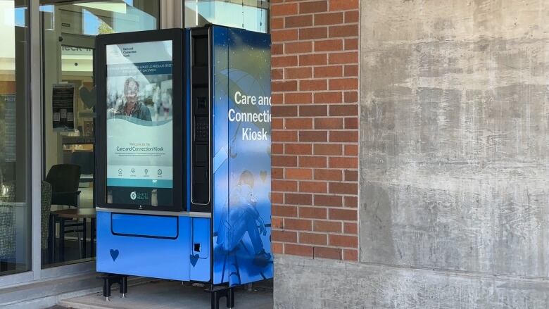 A blue vending machine with a touch screen outside of the Nanaimo emergency room. It dispenses harm-reduction utensils. 