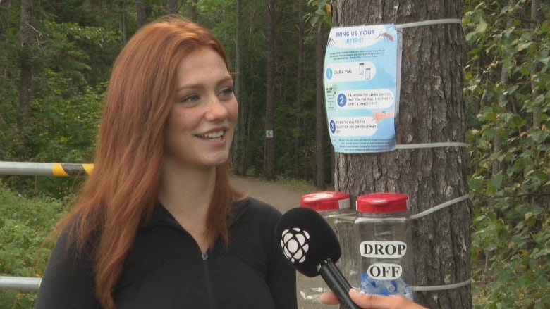 A white lady with red hair doing an interview.