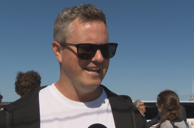 a man with black sunglasses and a blue sky