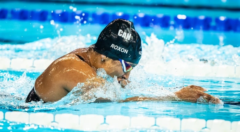 A swimmer rises for air mid-race.