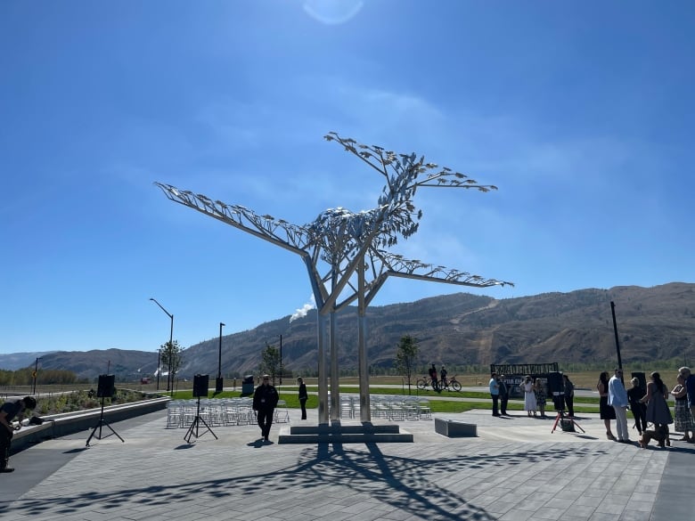 A stainless steel structure showing an airplane in flight at a park.