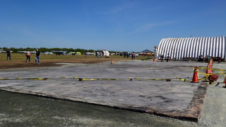 An empty piece of concrete surrounded by caution tape and orange cones. 