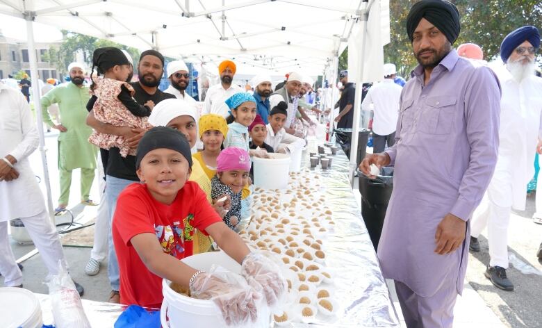 A group of children standing in front of a table with sweets 