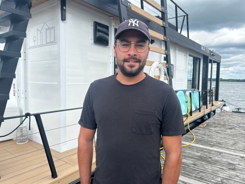 white man wearing a black shirt and yankees baseball cap on a boat