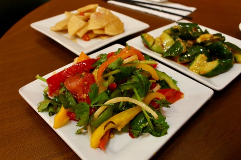 A colourful plate of vegetables sits on a white plate.