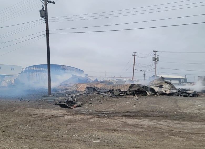 Smoke billows from the remains of Whale Cove's only store, lost to a fire in August 2024. 