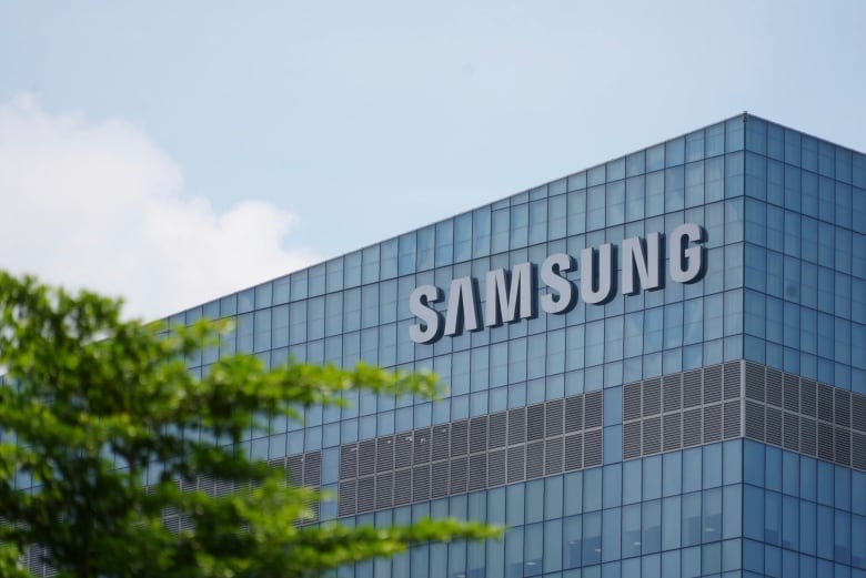 A blue Samsung logo is seen on a glass high-rise building on a sunny day.