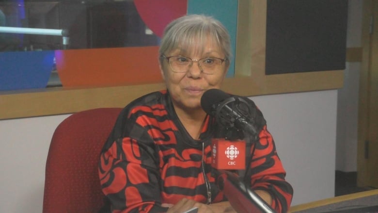 An Indigenous woman speaks in a radio studio.