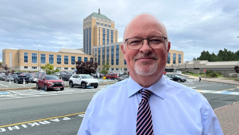 a portrait style photo of Fred Hutton, with Confederation Building in the background.