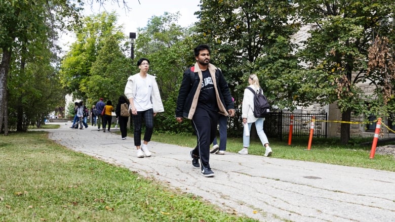 People walk down sidewalk 