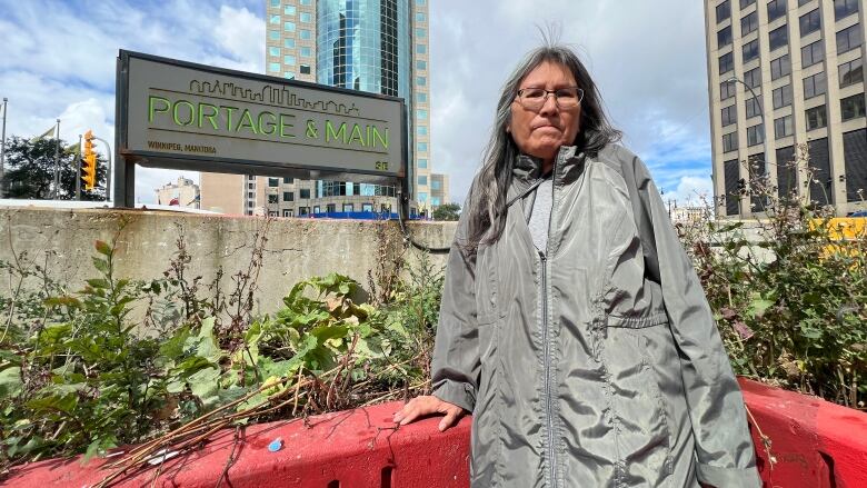 A woman is standing in front of a sign that says 