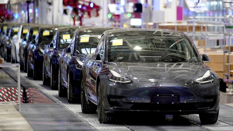 Vehicles are shown on an assembly line inside a manufacturing facility.