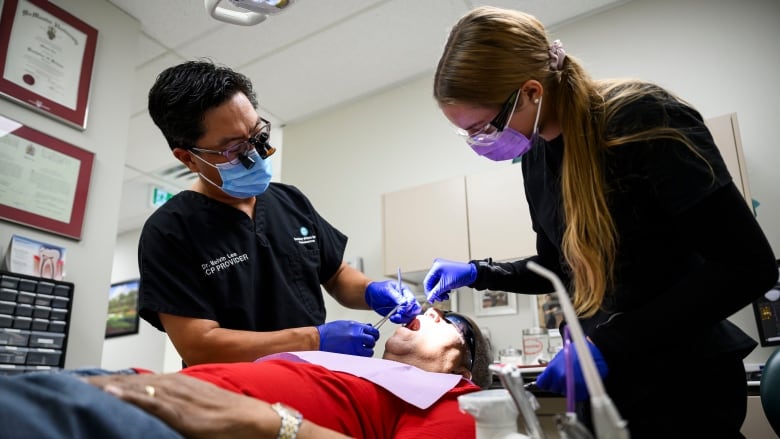 A dentist preforms work on a patient.