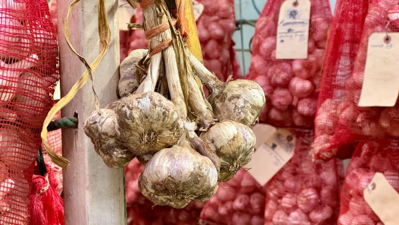 Garlic hangs from a shelf.