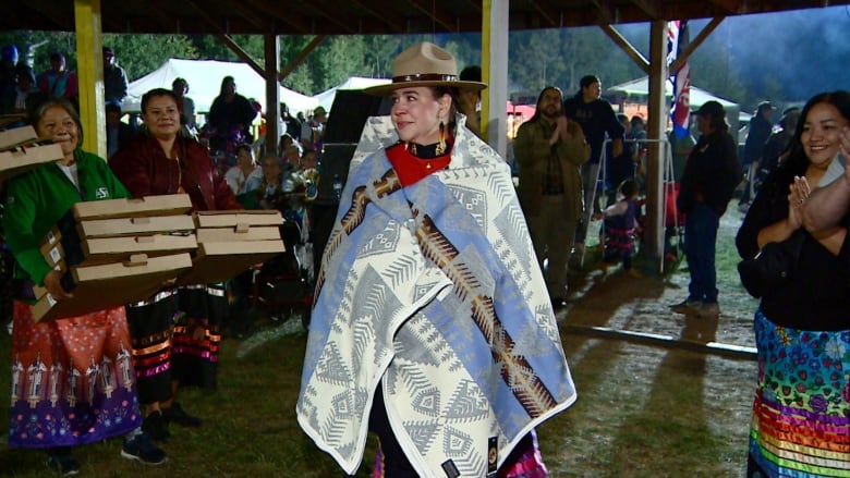 A woman in RCMP regalia wrapped in a blanket