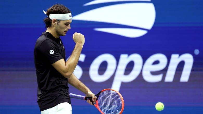 A men's tennis player celebrates.