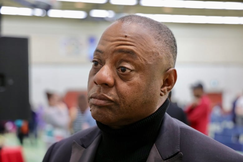 Man in black turtleneck and blazer. 