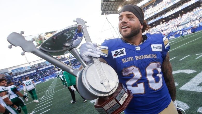 A football player holds up a trophy 