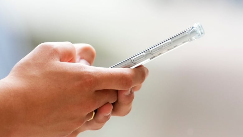 A person's hand holding a cellphone.