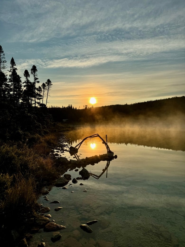 A layer of mist rises over a body of water. 