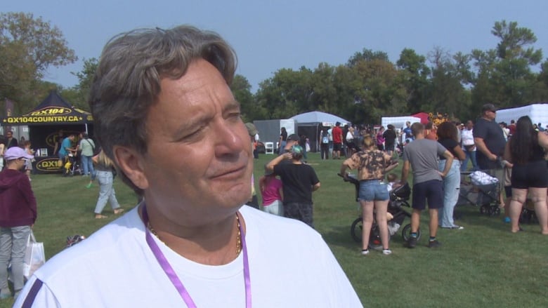 A man speaks to a reporter. 