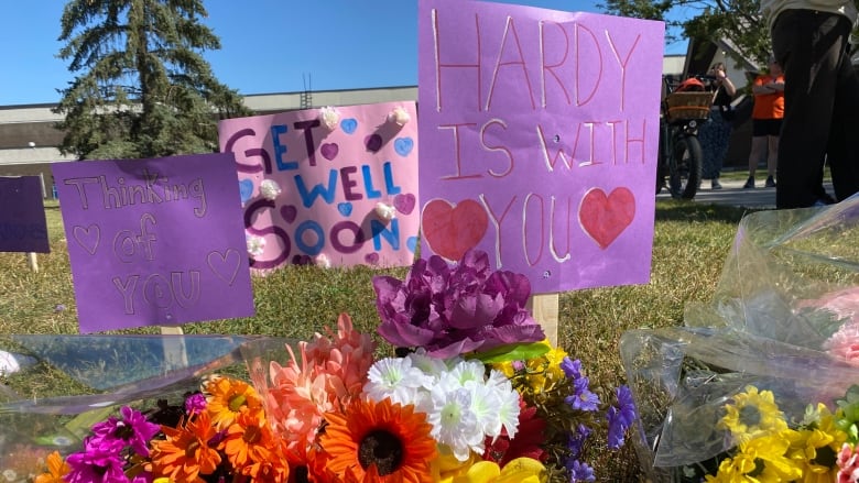 Flowers and signs on grass.