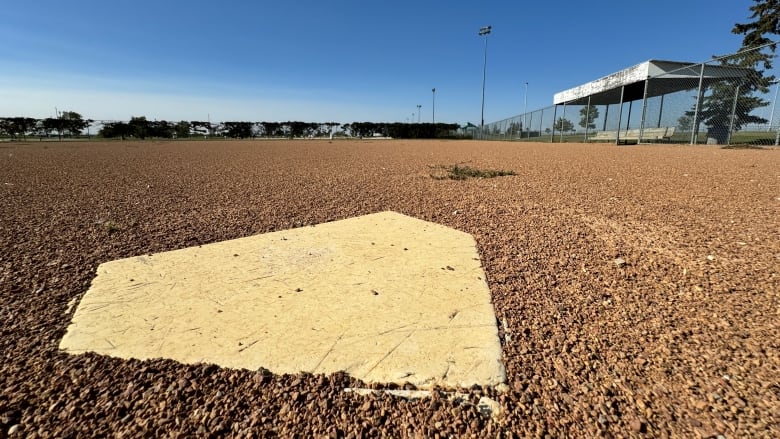 A home plate sits in the dirt of a baseball diamond.