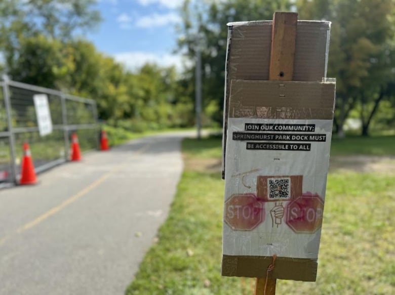 a sign with a QR code for a petition outside of a construction zone at a dock along the Rideau River waterfront