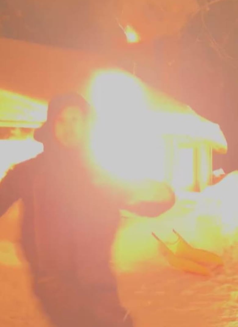 A grainy screen grab of a man running a way from an explosion