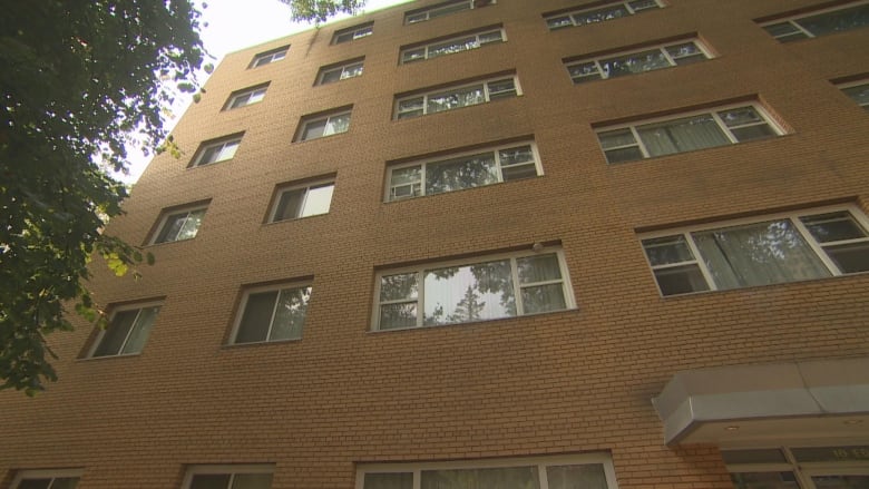 The exterior of a brick apartment building featuring a number of windows.