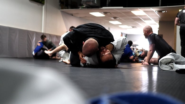 Two athletes grapple in a Jiu-Jitsu hold