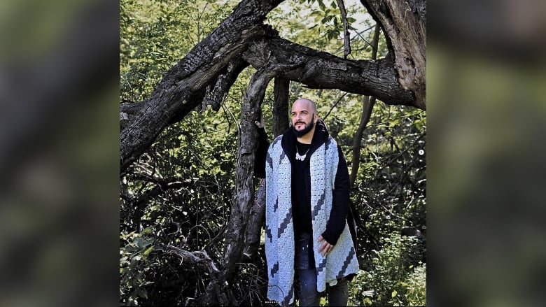 A man stands in a forest.