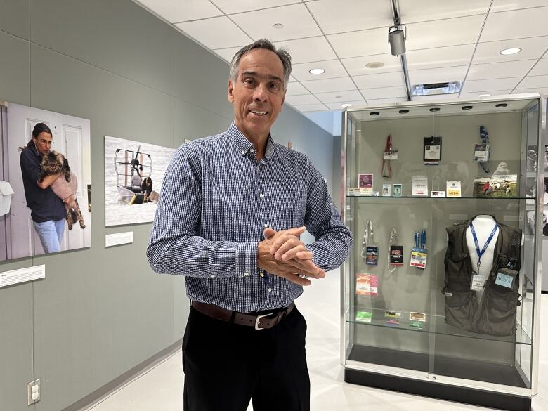 A man stands amidst a photo exhibition at a museum.