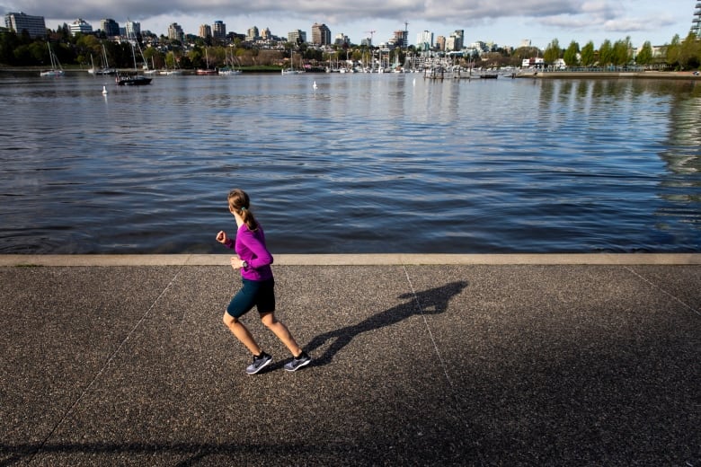 A woman in a purple sweater runs. 