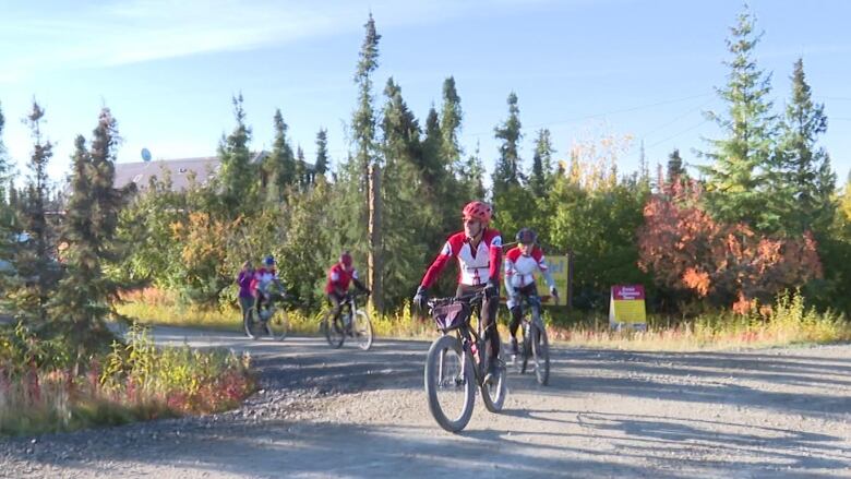 A group of cyclists on a gravel road.