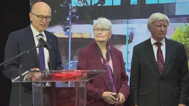 three people on stage at an event