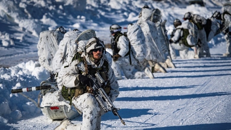 Canadian Army soldiers from 3rd Battalion, Royal 22e Rgiment, prepare to move out from a landing area after disembarking from a CH-147 Chinook helicopter in the training area of Fort Greely, Alaska, United States, during training at the Joint Pacific Multinational Readiness Center on March 16, 2022.