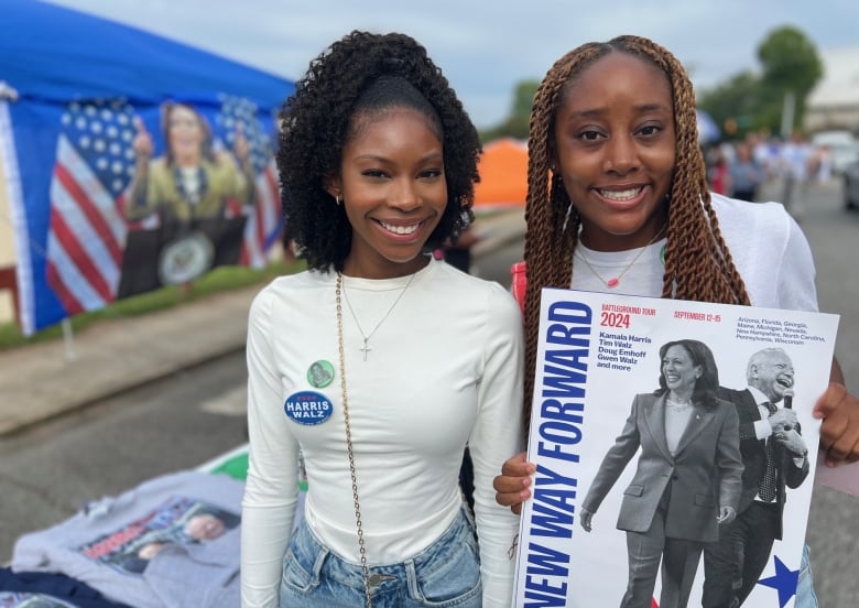 Two young women. One holds a New Way Forward sign