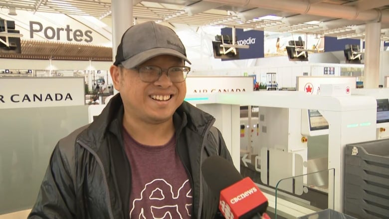 A man is shown at an airport.