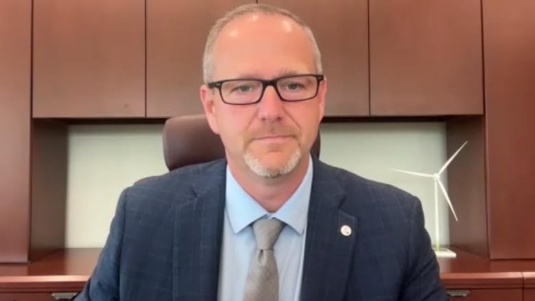 Man wearing a suit looking at camera with neutral expression.