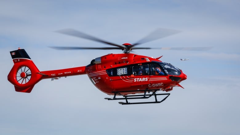 A red helicopter with white lettering reading 