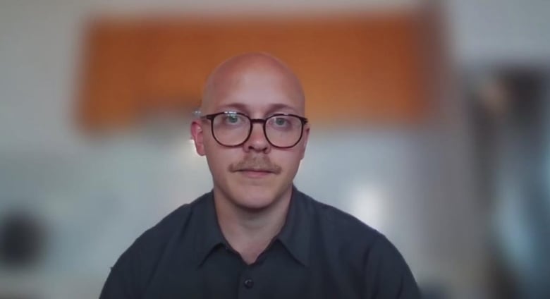 A man in glasses without appears in a video call. 