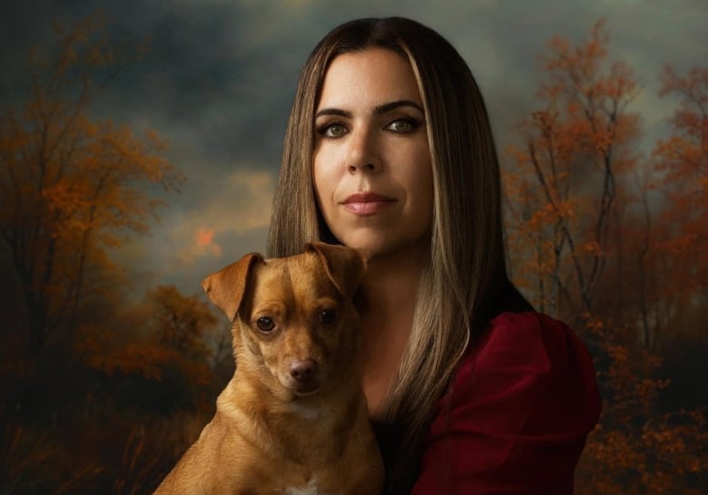 Brown haired woman posing with her small brown dog on her lap.