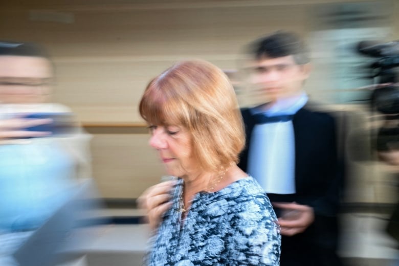 A blurred photo of an  older  woman in a flowered dress