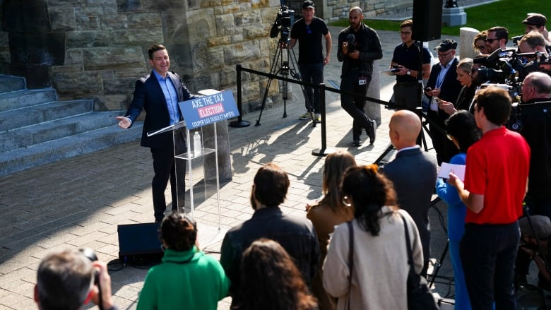 Pierre Poilievre stands outside of West Block in front of many reporters.