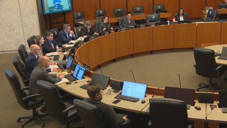 A group of people sit on chairs in a chamber