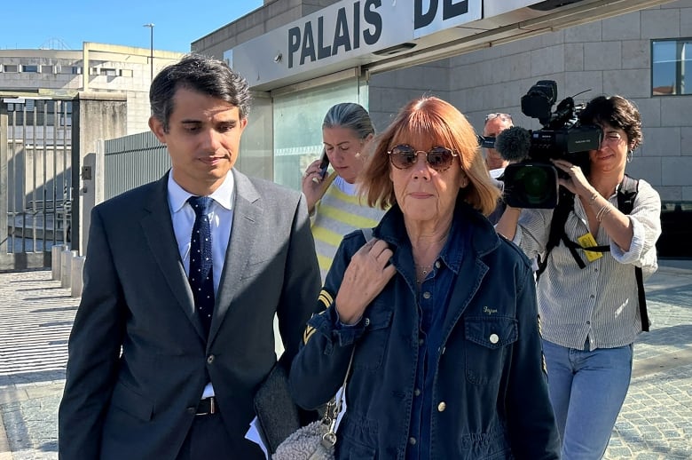 An older woman walks out of a courthouse