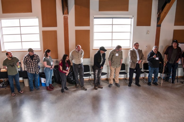 People gathered in a room in a circle. One person speaks.  