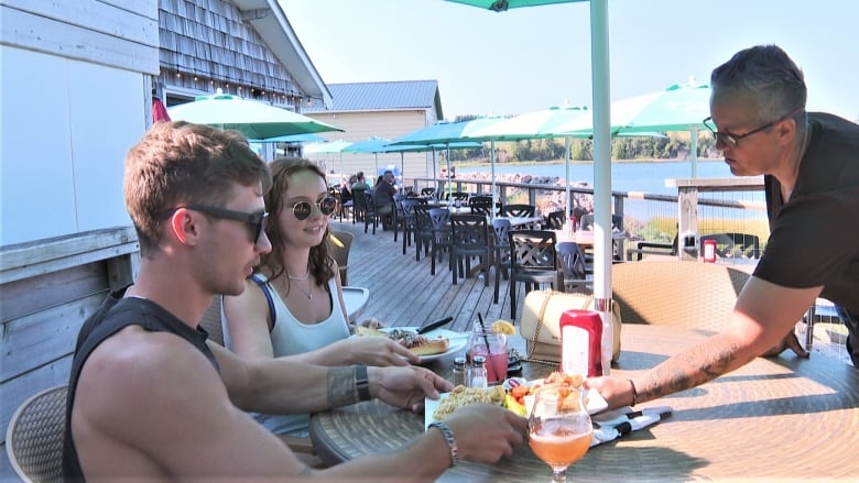 Couple on patio in sleeveless tops.